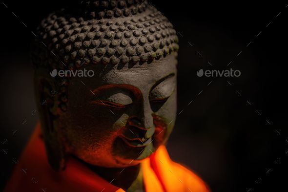 Closeup of Buddha sculpture in dim lighting