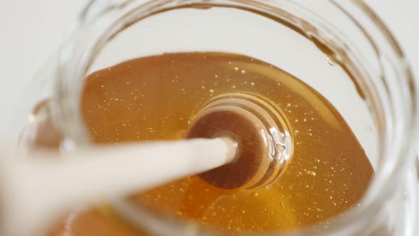 Wooden kitchen utensil dipped in sweet food substance 4K 2160p 30fps UltraHD footage - Spiral honey  alt