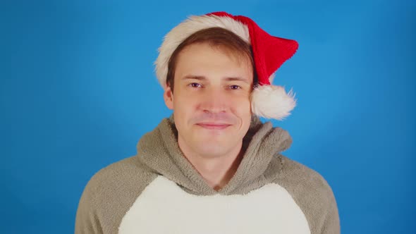 Handsome Man in Santa Hat Looking at Camera and Smiling alt