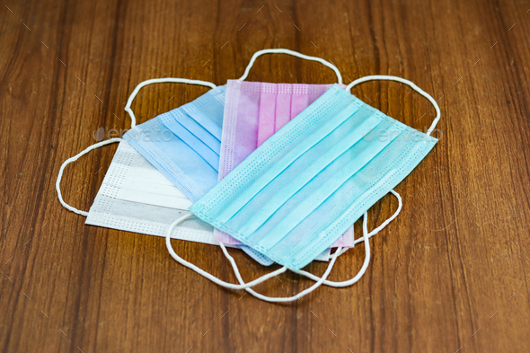 Shot of colorful surgical cotton masks on a wooden surface