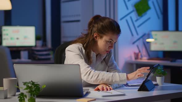 Manager Woman Using Laptop and Tablet in Same Time Working Overtime alt