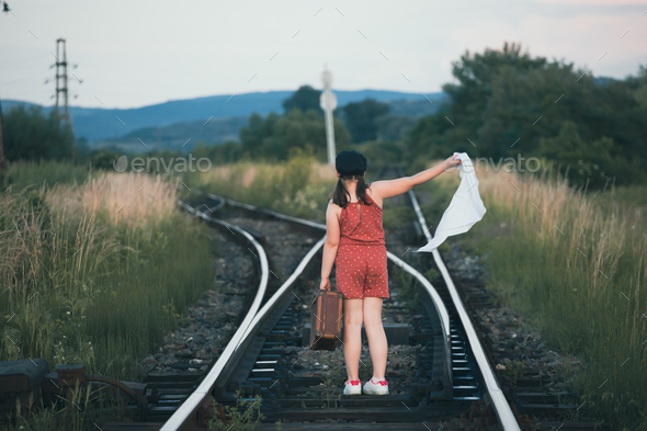 A little girl in a dress walking on an abandoned railroad tracks Stock ...