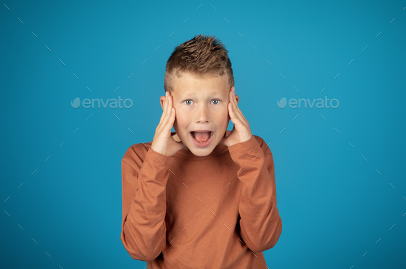 Omg. Portrait Of Shocked Preteen Boy Touching Face And Looking At ...