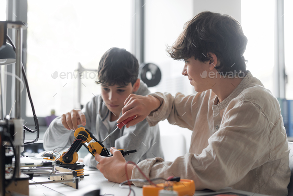 Young students using a 3D printer in the lab