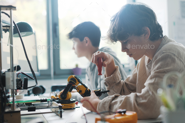 Young students using a 3D printer in the lab