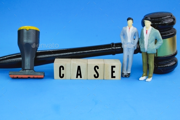 miniature people, judge\'s gavel and stamp with the word case.