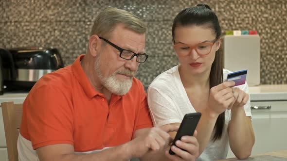 Beautiful Young Woman Is Explaining To Her Elderly Father How To Shop Online alt
