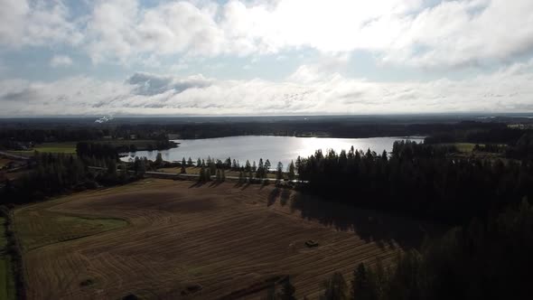 Drone shot flying over a lake and farmland in Oulanka National Park, Finland alt