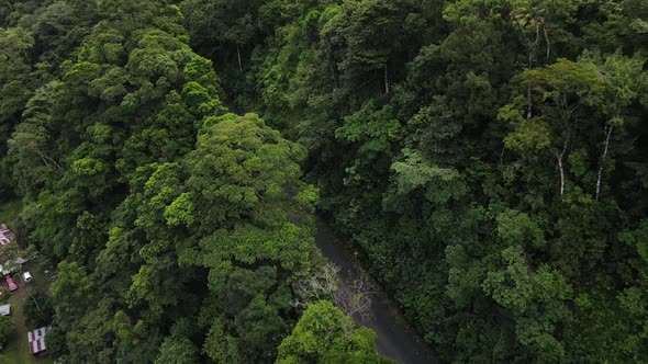 Drone approaching road leading through the thick rainforests of Costa Rica near La Fortuna. Wet natu alt