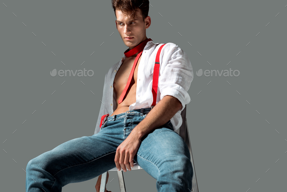 hot young man in white shirt sitting on chair on grey Stock Photo by  LightFieldStudios