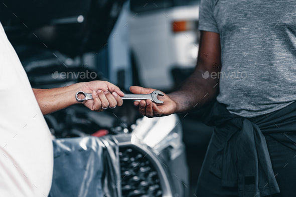 Mechanics Hand send a wrench tool to a friend. Automobile Garage Worker Teamwork