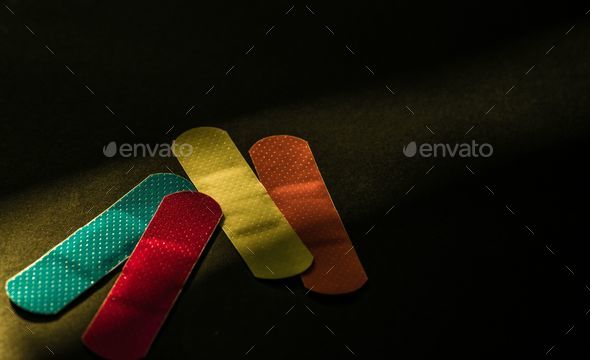 Close up of colorful wound patches on a khaki table with black background