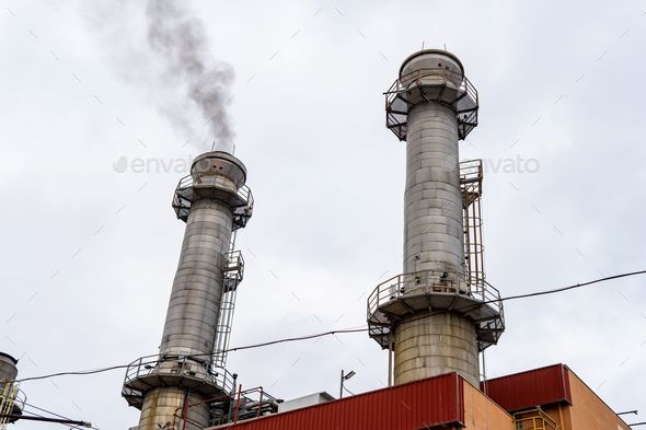 Photo of factory chimneys emitting black smoke. Concept of pollution crisis, ozone layer, global war