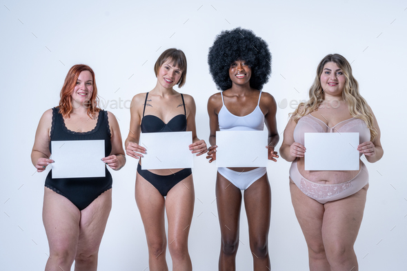 Multiracial group of women holding blank white board over belly, body positive concept