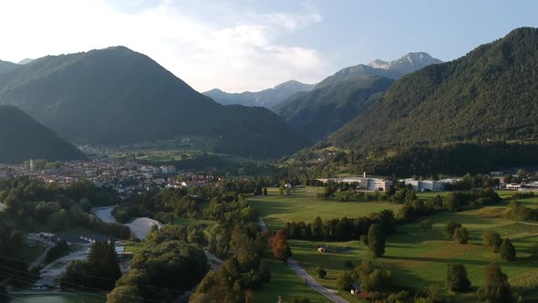 Aerial drone shot of the town of Tolmin in Slovenia with a mountain range backdrop. alt