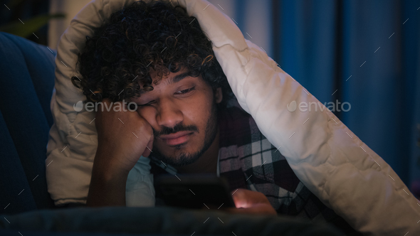 Sad sleepy guy Latino tired man upset Arabian sleeping napping boring Indian male at night evening