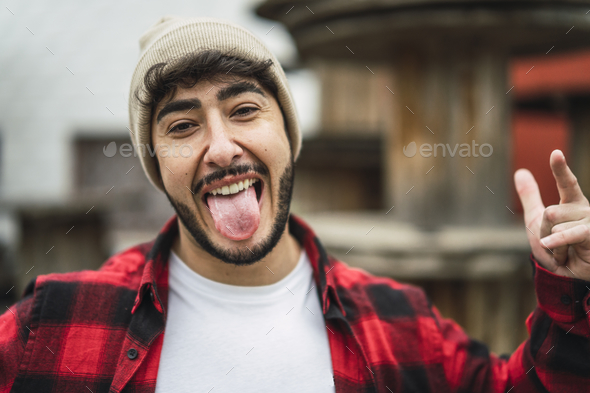 Portrait of a crazy Spanish guy wearing stylish clothes on background of industrial spools
