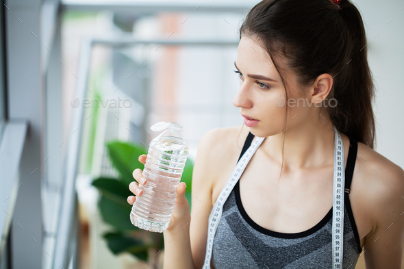 Teenage girl drinks water from bottle Stock Photo by