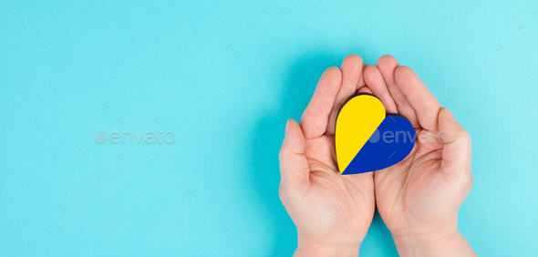 Holding a heart with the flag of Ukraine, national idendity, war crisis between Ukraine and Russia