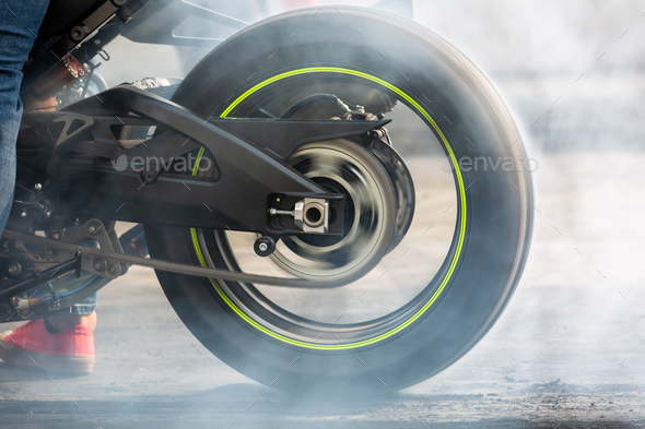 Motorbike burning tire rubber on road, Motorbike wheel drifting and white smoking on track.