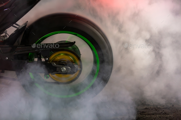 Motorbike burning tire rubber on road, Motorbike wheel drifting and white smoking on track.