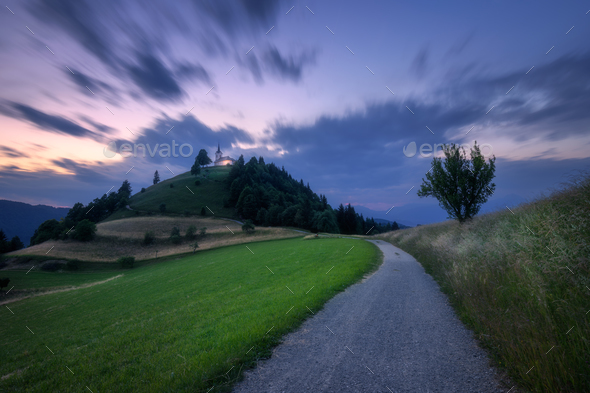 Rural road and chapel on the mountain peak at twilight