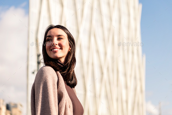 smiling young woman taking a walk enjoying city - Stock Photo - Images