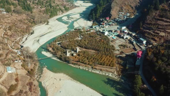 Aerial drone shot of  bridge over the Bhagirathi river flowing through sands in Harshil Village