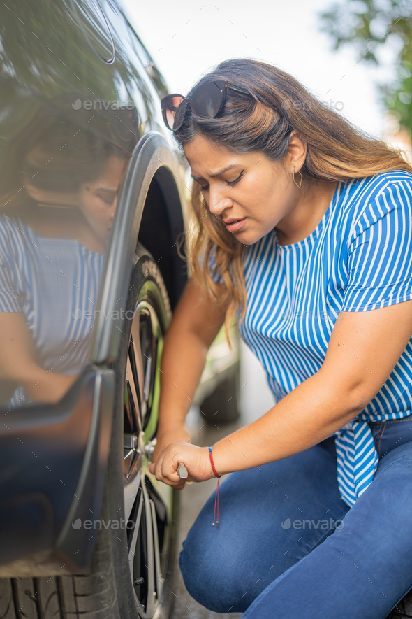 Woman changing her car tire