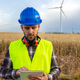 Male wind turbine farm maintenance worker checking data on digital tablet. Vertical image. - PhotoDune Item for Sale