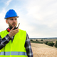 Male construction worker communicating with walkie-talkie. Copy space. - PhotoDune Item for Sale