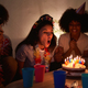 A young woman blowing out the candles on her birthday cake while celebrating her birthday - PhotoDune Item for Sale