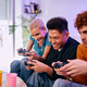 Three concentrated friends playing video games in the living room of their apartment - PhotoDune Item for Sale
