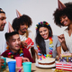 A young woman admiring her birthday cake together with her friends at her birthday party - PhotoDune Item for Sale