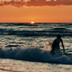 Female silhouette walking in sea waves at summer sunset, half sun below horizon, beachfront holiday - PhotoDune Item for Sale