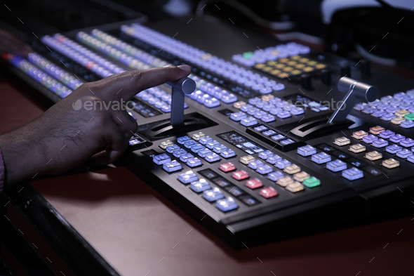 Hands on dissolve of Switcher buttons in studio TV station, Audio and Video Production Switcher of T