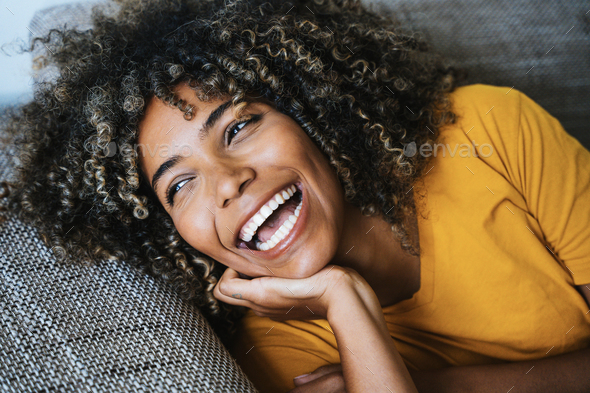 Happy black woman relaxing lying on the sofa at home Stock Photo by ...