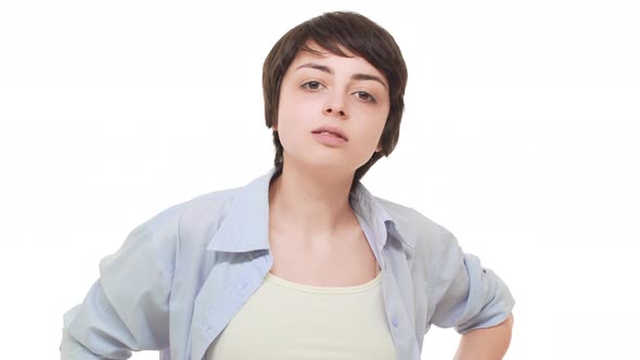 Arrogant Young Caucasian Female Standing Over White Background Chewing Gum and Staring at Camera alt