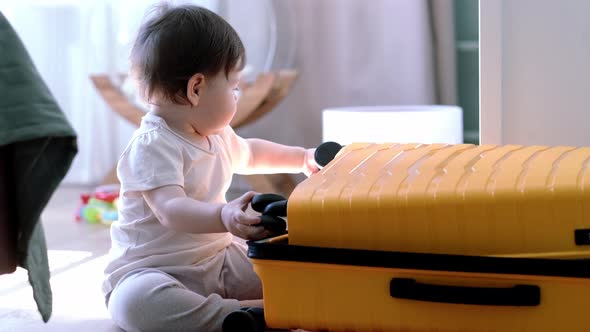 Baby Girl with Yellow Suitcase Baggage and Clothes Ready for Traveling on Vacation Child Playing alt