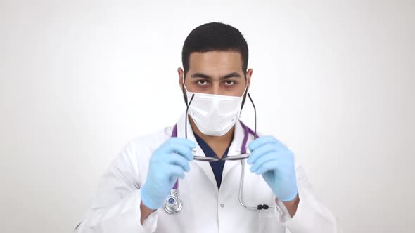 Arab young doctor in medical mask smiling at camera. The end of the coronavirus pandemic alt