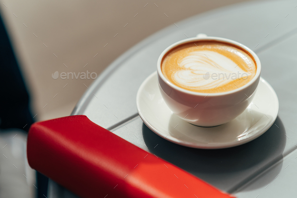 Cup of fresh hot aromatic cappuccino with latte art in shape of heart on a summer terrace - Stock Photo - Images