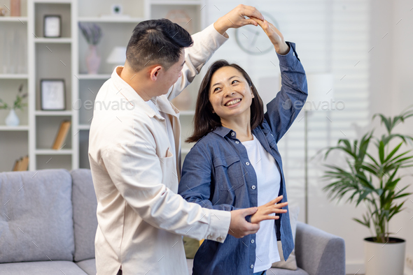 Happy Asian couple, young family man and woman celebrate moving to a new house, buying an apartment