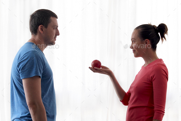 Woman gives apple to man