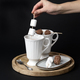 A woman&#39;s hand stirs hot chocolate with marshmallows and chocolates skewers - PhotoDune Item for Sale