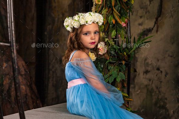 Little girl princess sitting on fairy bench in dark mystery room