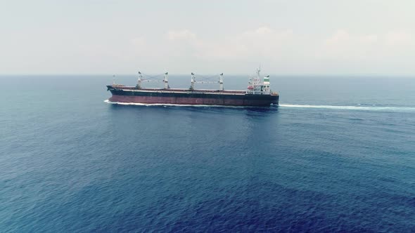 Drone Side View Of Commercial Ship Vessel On Deep Blue Sea
