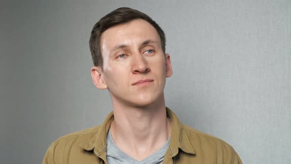 Man Kneads Neck Tilting Head to Sides on Grey Background alt
