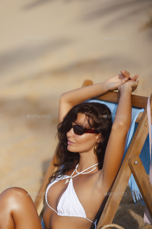Fashion Holiday Photo of Tanned Woman in Chic White Bikini on a Beach Chair - Stock Photo - Images