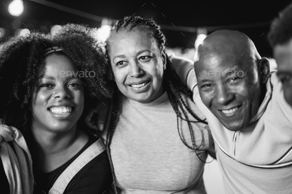 Happy african family smiling on camera at home garden party during night time