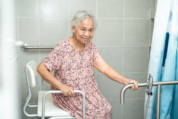 Asian elderly woman patient use toilet bathroom handle security in nursing hospital. - Stock Photo - Images
